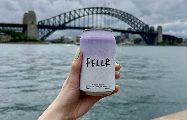 Fellr passionfruit brewed alcoholic seltzer in the foreground with the Sydney Harbour Bridge in the background.