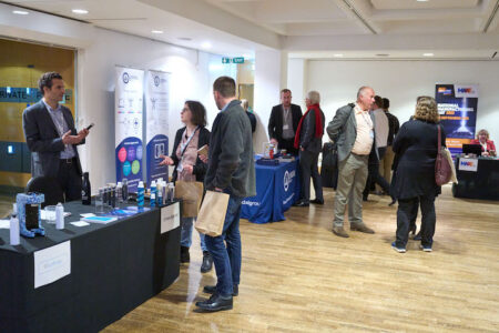 Visitors attend the BAMA Innovation Day exhibitor tabletops.